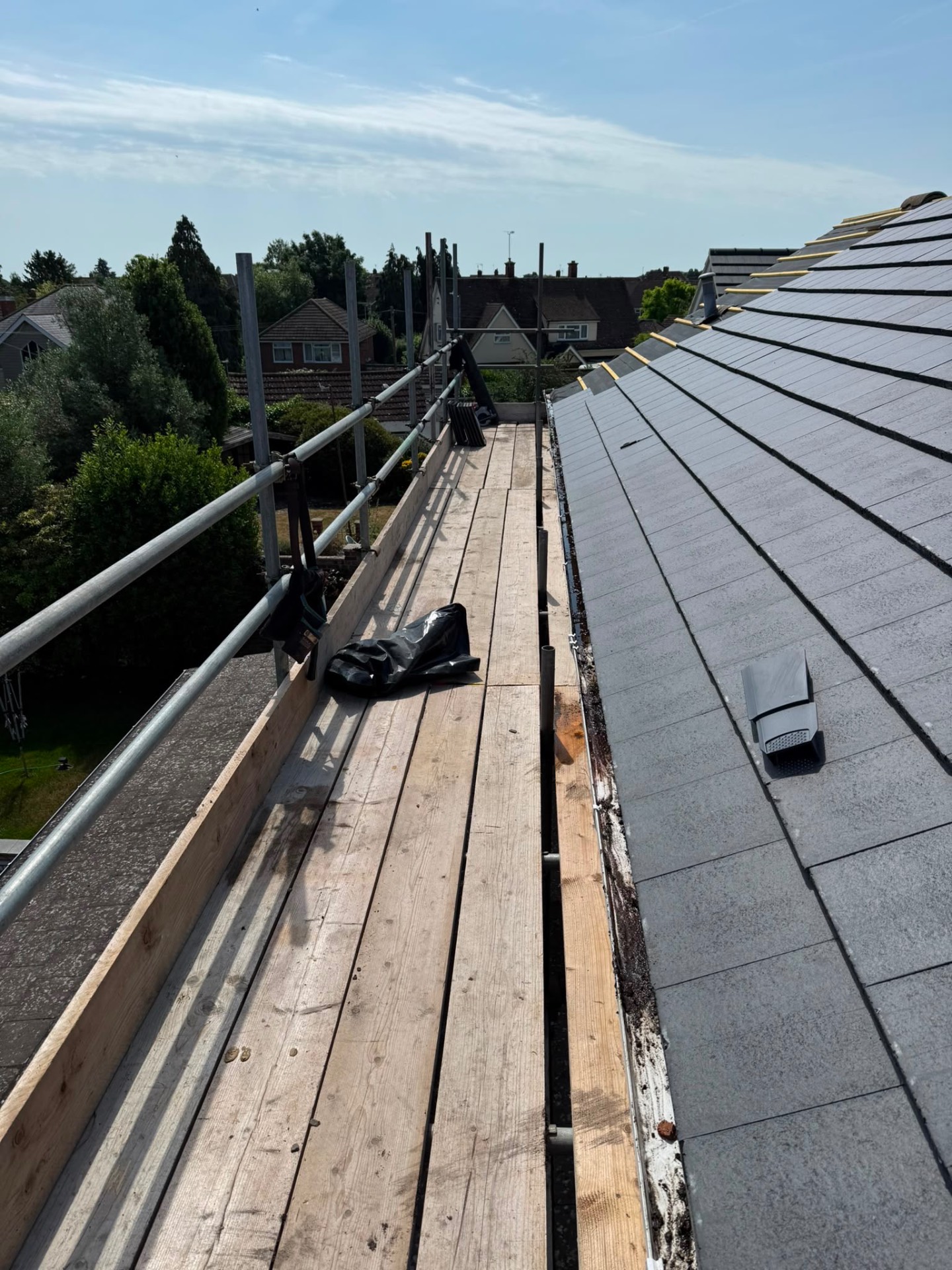 New grey slate roof from scaffold with roof vent and ridge detail
