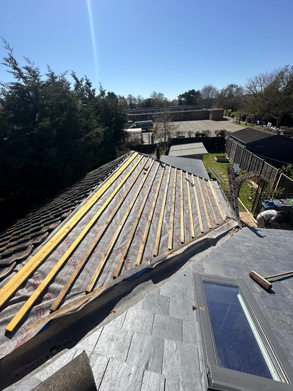 Sunny in-progress slate roof with fresh timber battens over breather membrane