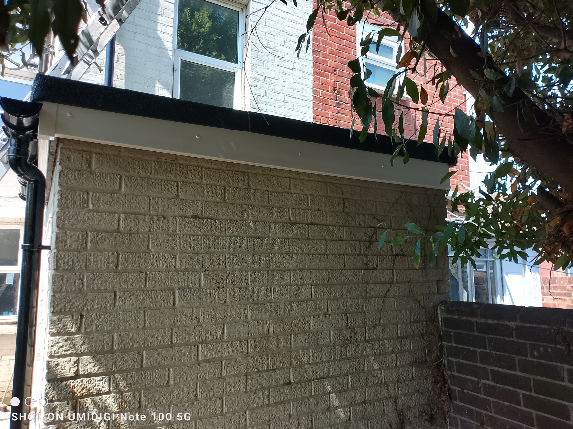 New white uPVC fascia, soffit and black trim above painted brickwork