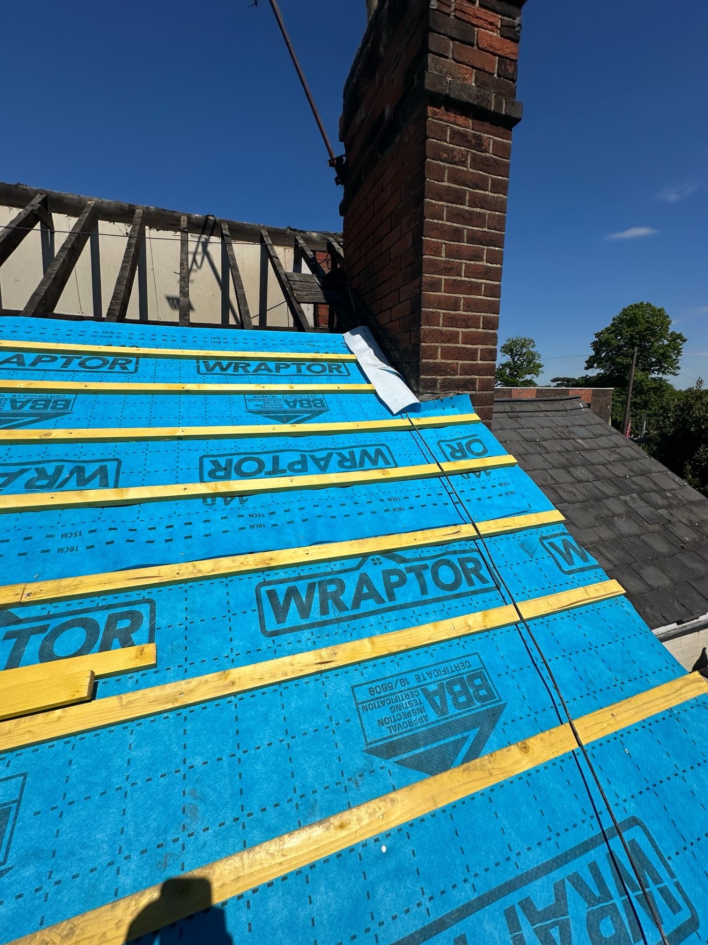 Wraptor breather membrane and treated battens under bright blue sky