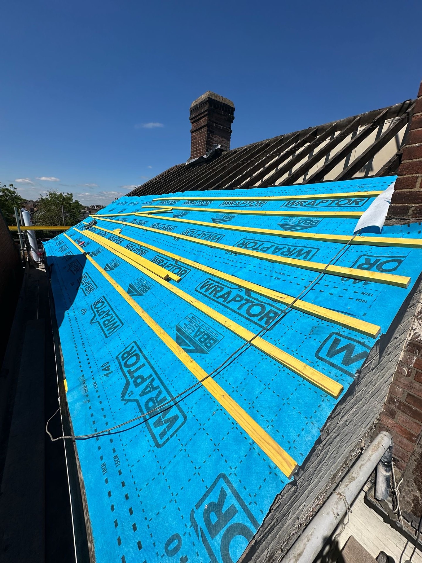 Wraptor breather membrane laid out beneath fresh treated battens