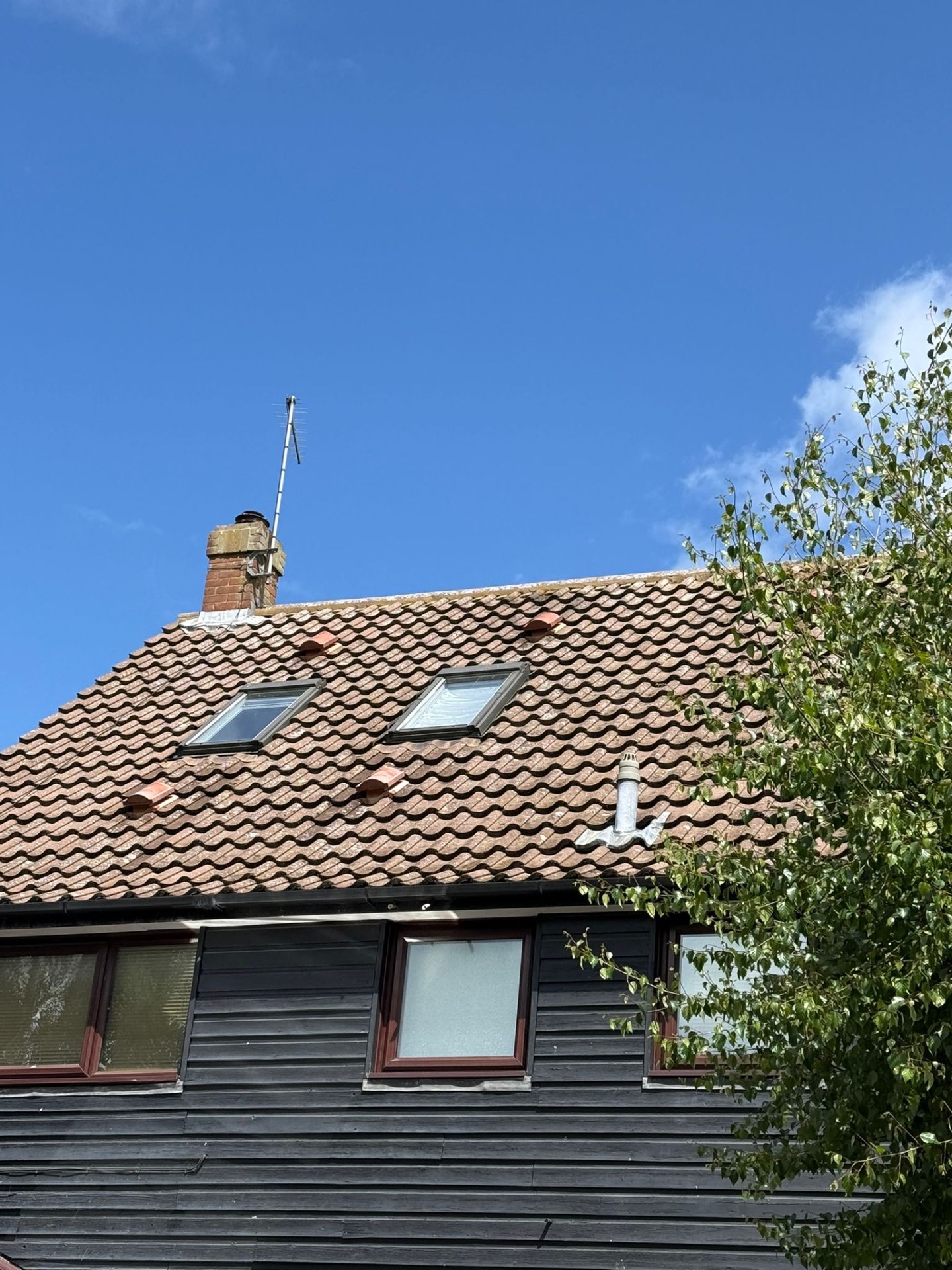 Finished clay pantile roof with dormer skylights and brick chimney