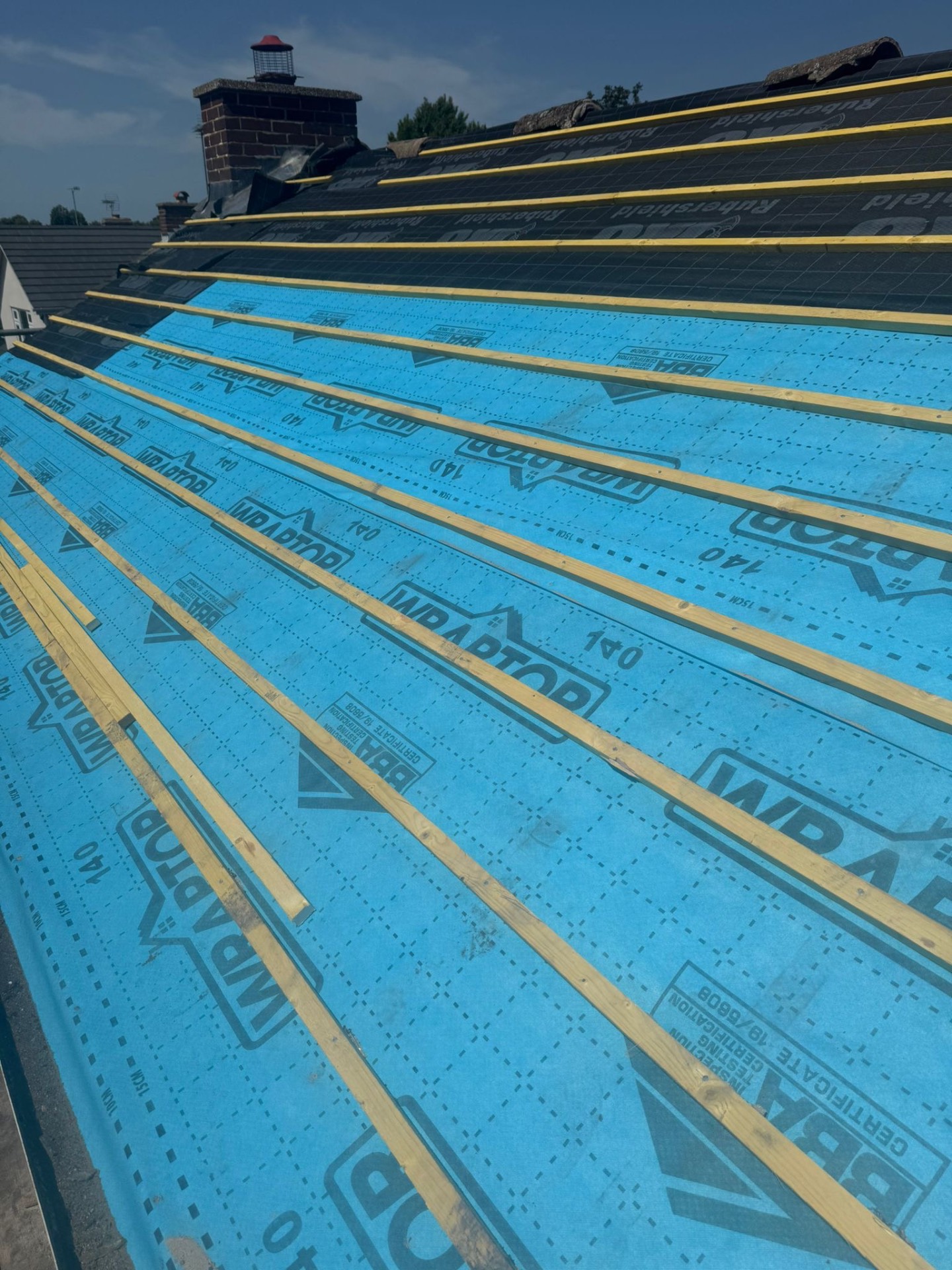 Long view of Wraptor breather membrane and battens running up to chimney stack