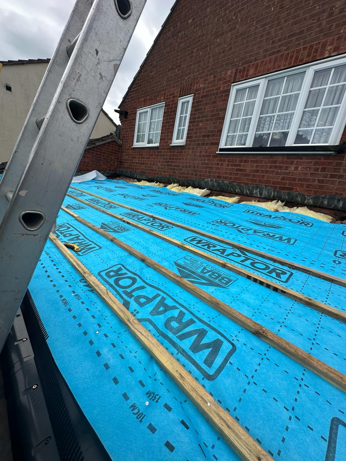 Fresh blue Wraptor breather membrane and treated battens laid over insulation