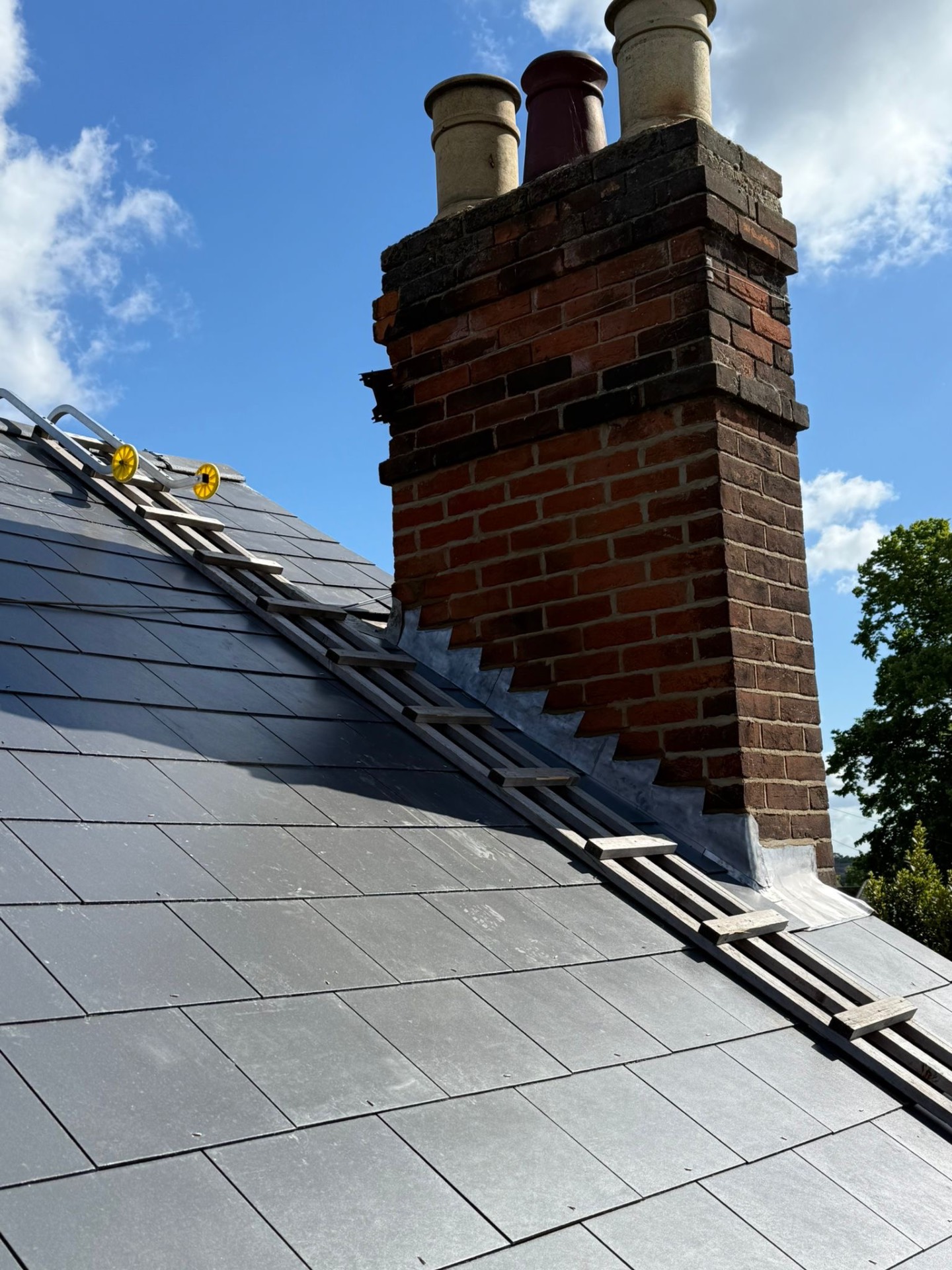 Precision leadwork stepping down brickwork of a chimney stack
