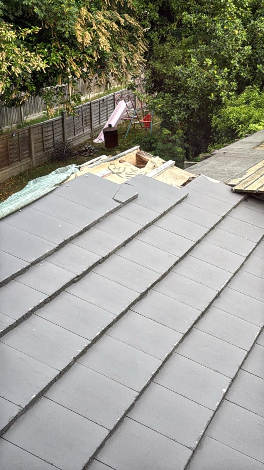 Neatly mortared grey slate roof with ridge point-up in progress