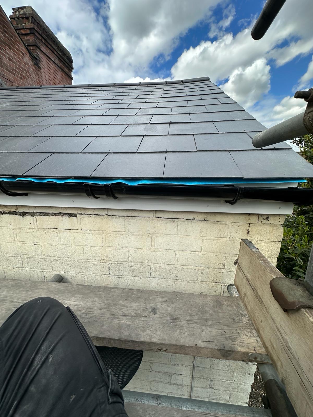 New slate roof over black seamless guttering and painted fascia board