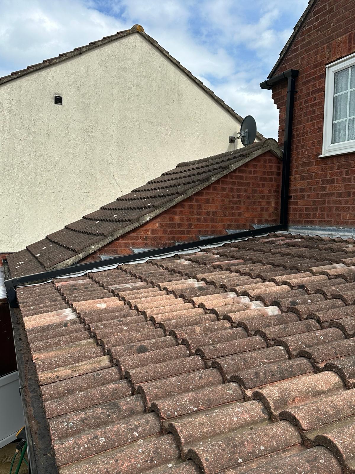 Pantile roof with fresh black trim meeting brick party wall