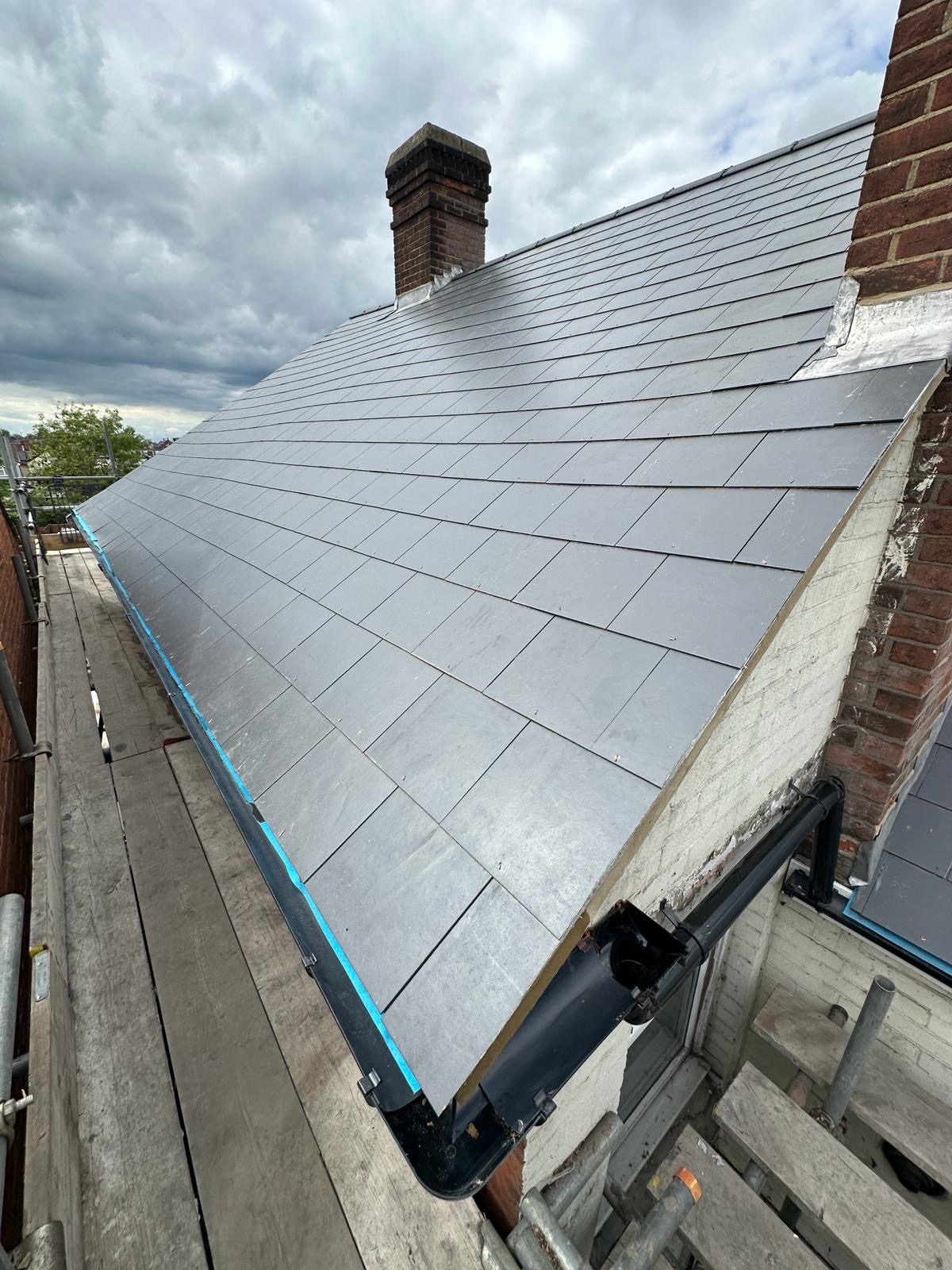Full slate pitched roof with brick chimney and lead flashing, viewed from scaffold