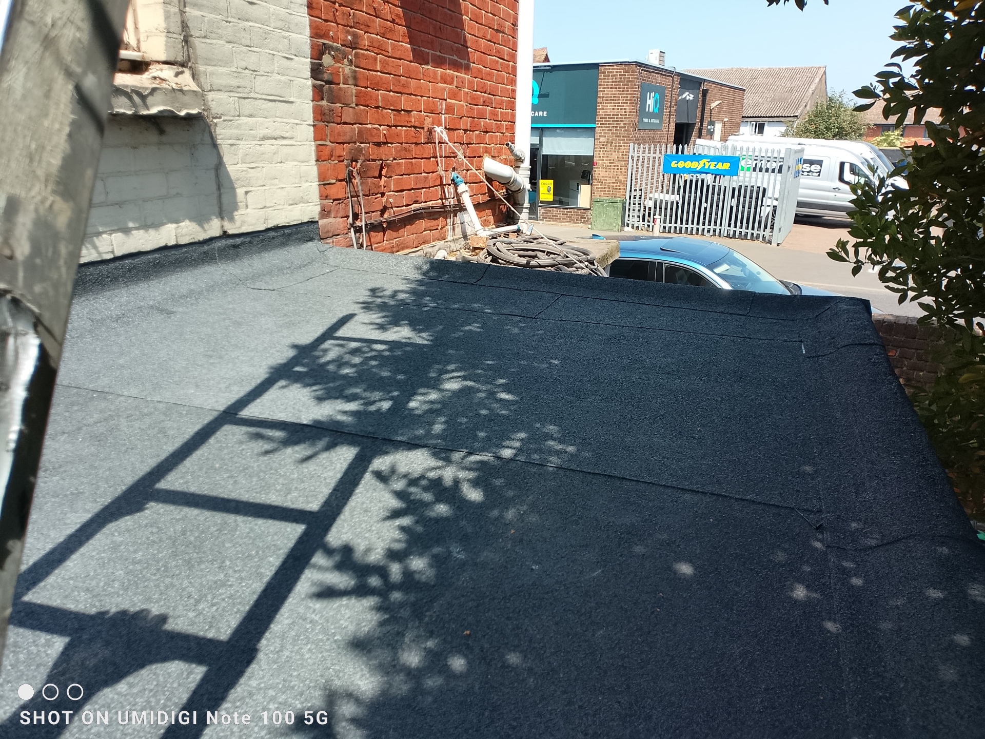 Newly finished torch-on felt flat roof with clean laps and neat detailing