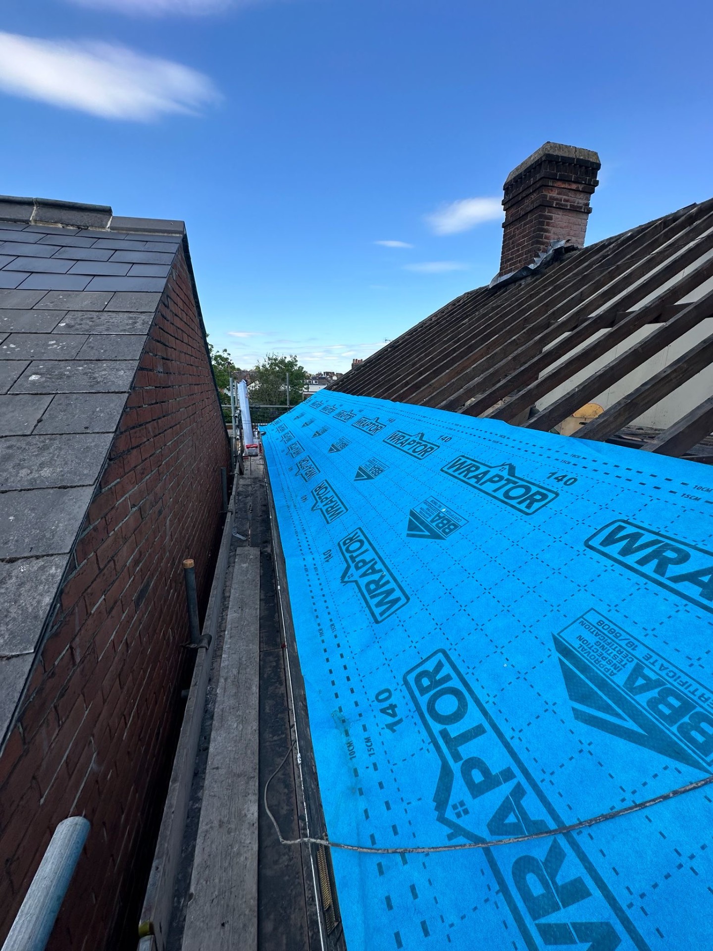 Wraptor membrane wrapped up to a slate party wall on a terraced roof