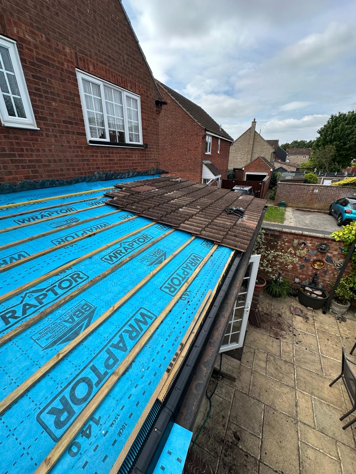 Half-tiled roof reveal showing Wraptor membrane and yellow battens