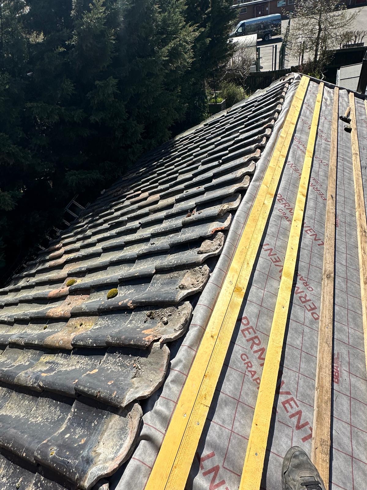 Old weathered clay pantiles stripped off ready for a new roof