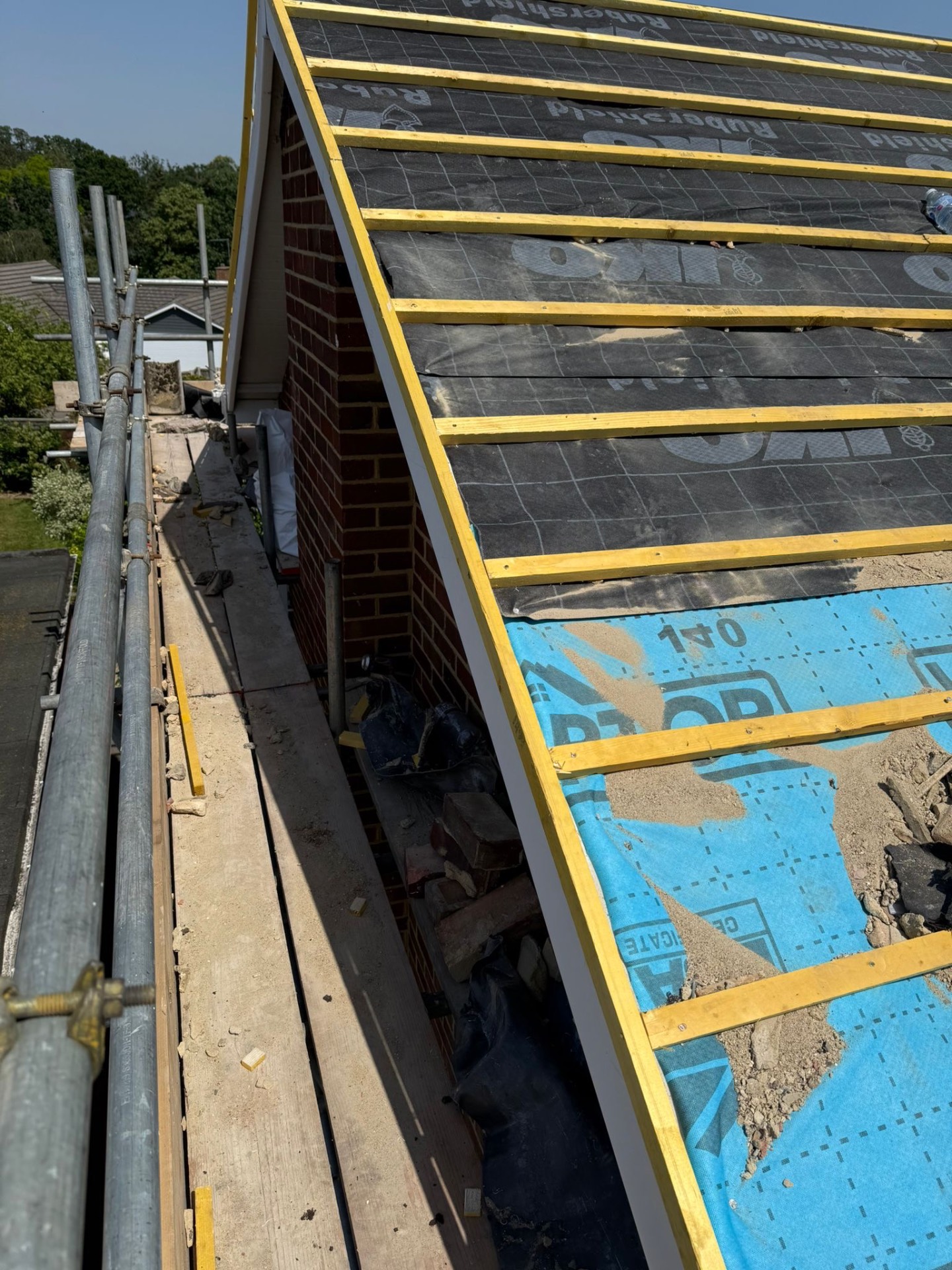 Gable end re-roof in progress with fresh yellow battens over Rubershield underlay