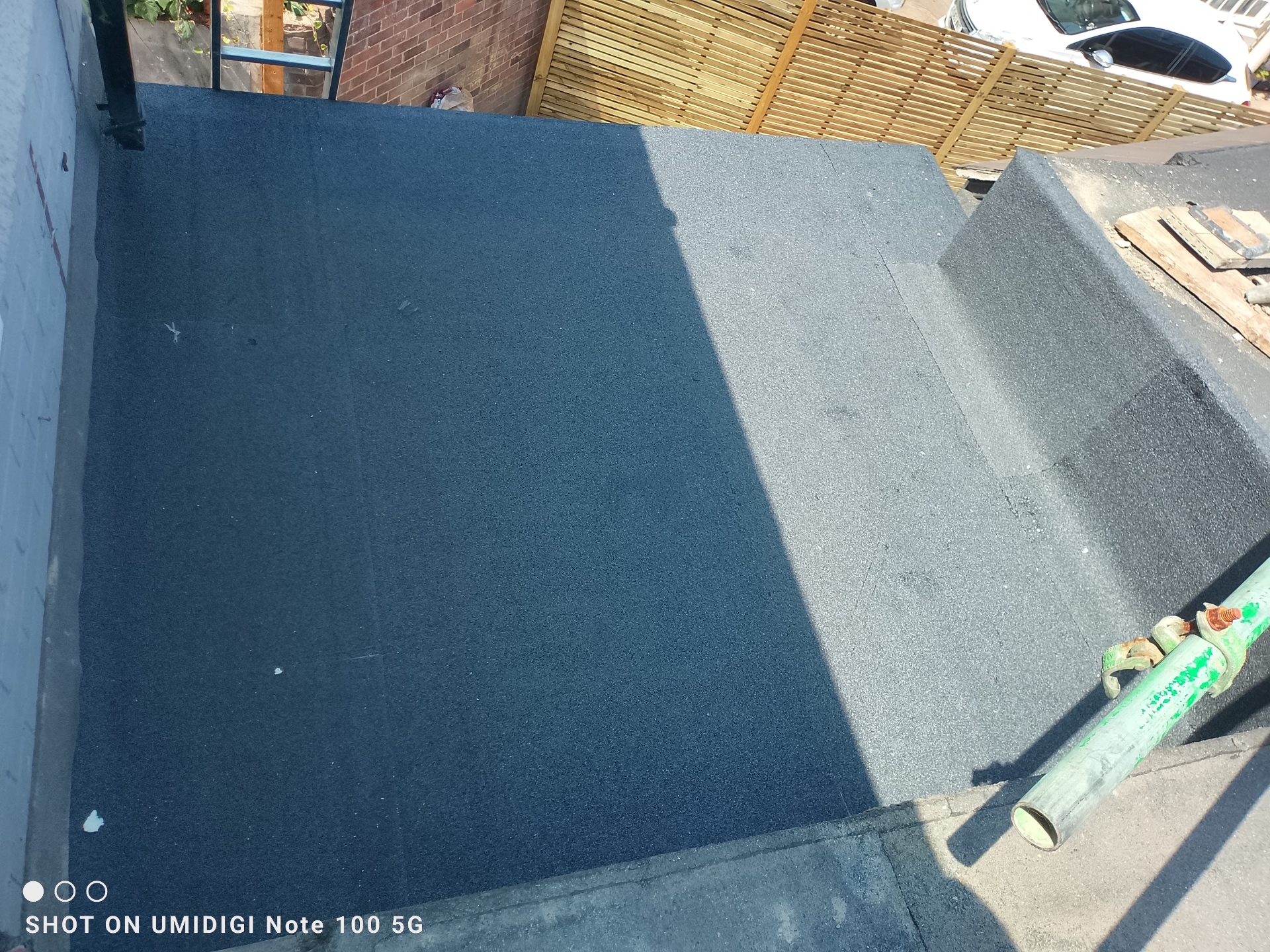 Close-up of a smooth new torch-on felt flat roof with clean laps